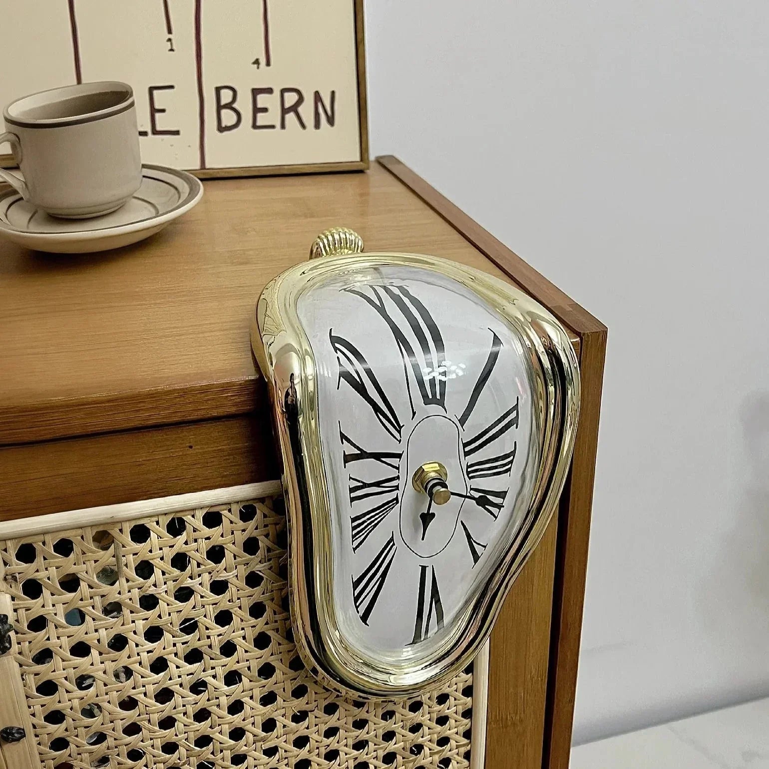 Gold melting clock with Roman numerals on wooden side table, cozy home decor accent
