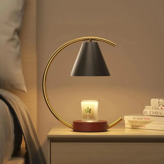 Modern gold arc lamp with black shade on bedside table, glowing candle, cozy bedroom ambiance