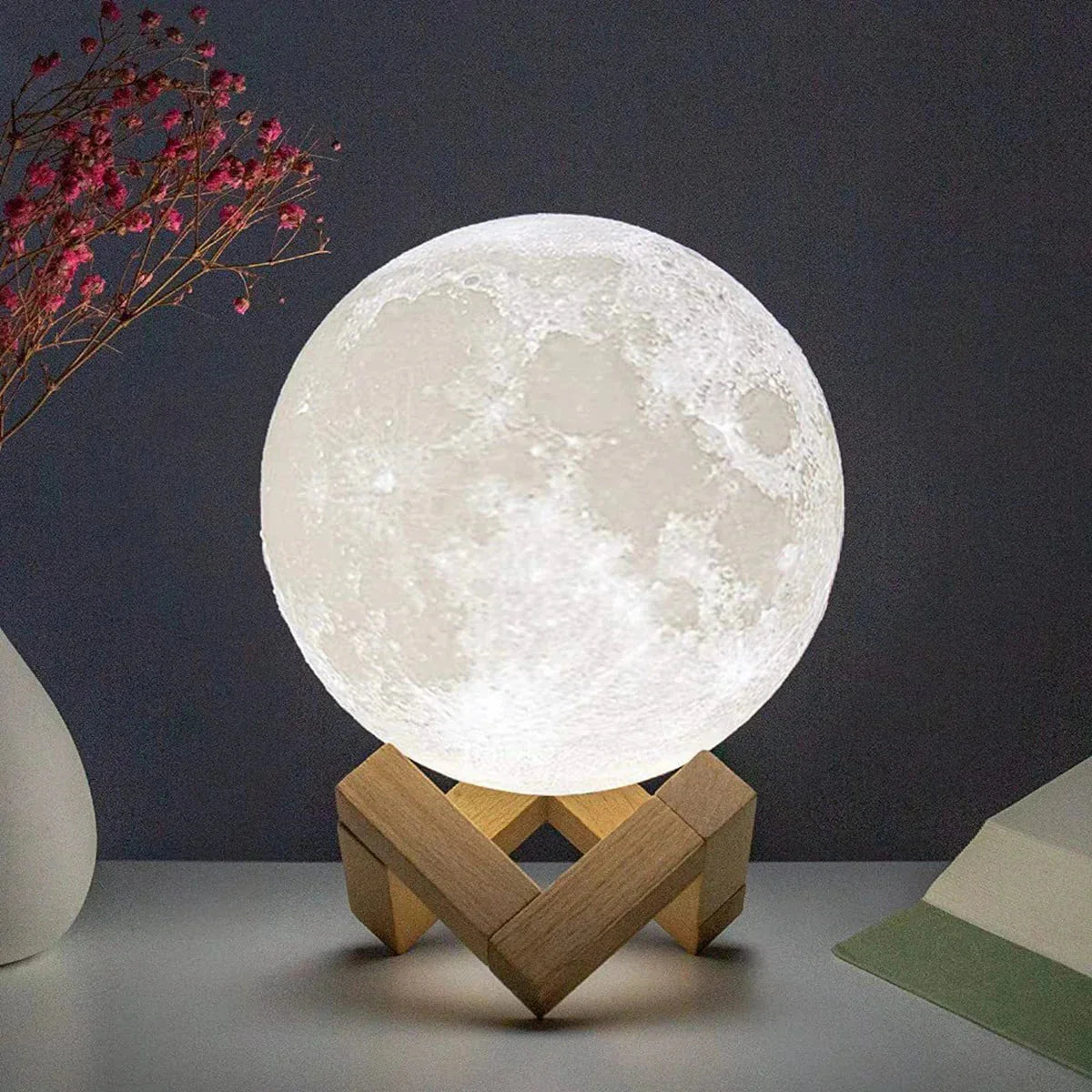 Glowing 3D moon lamp on wooden stand, cozy bedroom nightlight with realistic lunar surface texture