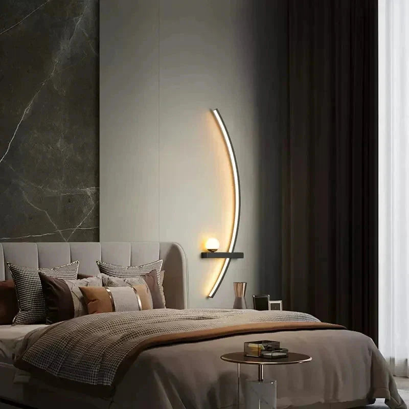 Modern curved wall sconce lighting cozy bedroom with marble accent wall and plush bedding