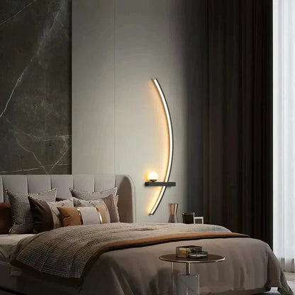 Modern curved wall sconce lighting cozy bedroom with marble accent wall and plush bedding